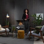 Element4 Summum 70 3S and a lady relaxing at the guess room with Real Flame Burner with True-to-Nature Wood Logs